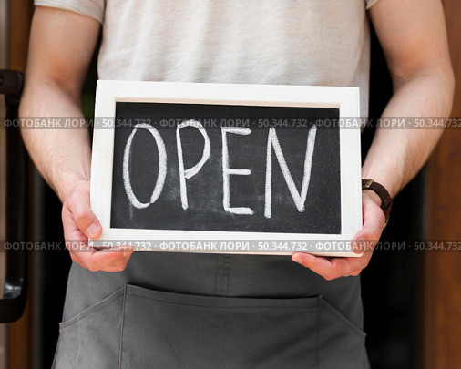 man holding we are open sign. Стоковое фото, агентство Ingram Publishing / Фотобанк Лори