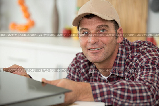 man installing an electronic hob. Стоковое фото, агентство Ingram Publishing / Фотобанк Лори