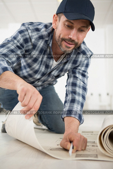 man is cutting linoleum flooring. Стоковое фото, агентство Ingram Publishing / Фотобанк Лори