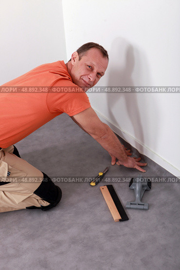 Man laying linoleum. Стоковое фото, агентство Ingram Publishing / Фотобанк Лори