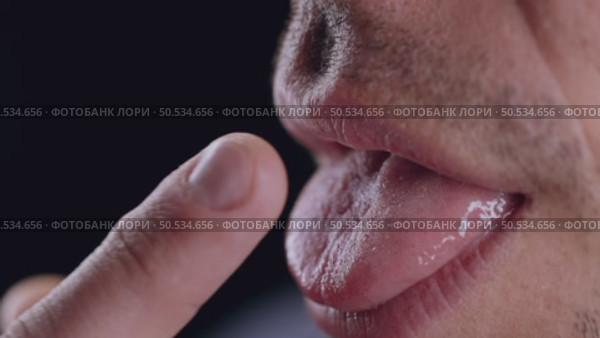 Man Licking Finger Demonstrating Bacterial Transmission Risk. Стоковое видео, видеограф Илья Шаматура / Фотобанк Лори