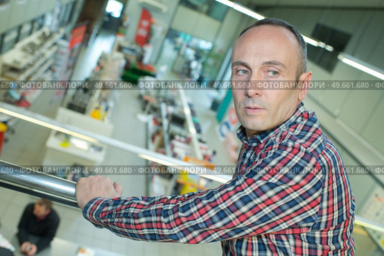 man looking at a factory from upstairs. Стоковое фото, агентство Ingram Publishing / Фотобанк Лори
