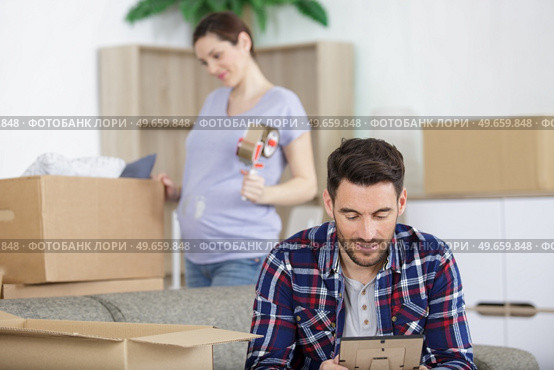 man looking at a frame while unpacking. Стоковое фото, агентство Ingram Publishing / Фотобанк Лори