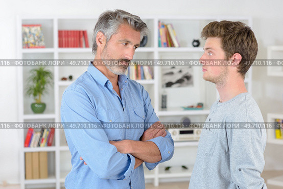 Man looking sternly at teenager. Стоковое фото, агентство Ingram Publishing / Фотобанк Лори