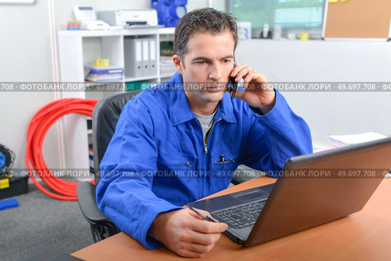 Man on telephone in front of computer. Стоковое фото, агентство Ingram Publishing / Фотобанк Лори
