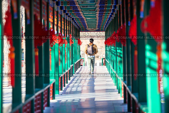 Man passing through the beautiful corridor with Chinese traditional ancient pavilions. Imperial City in the center of Beijing, China (2024 год). Стоковое фото, фотограф Кекяляйнен Андрей / Фотобанк Лори