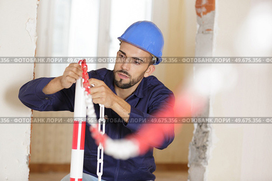 man preparing chains in site. Стоковое фото, агентство Ingram Publishing / Фотобанк Лори