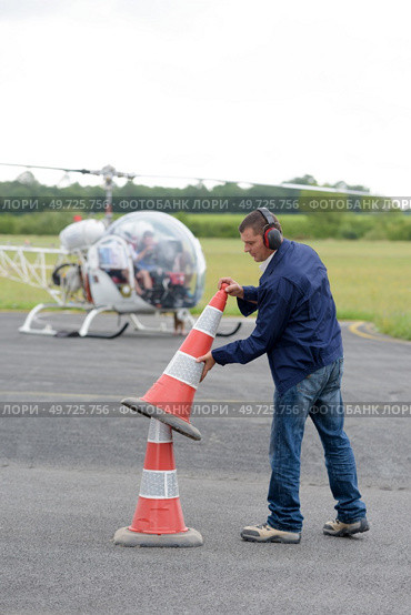man putting out safety cones at an airfield. Стоковое фото, агентство Ingram Publishing / Фотобанк Лори