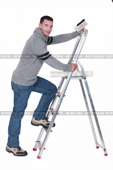 Man putting up wallpaper. Стоковое фото, агентство Ingram Publishing / Фотобанк Лори