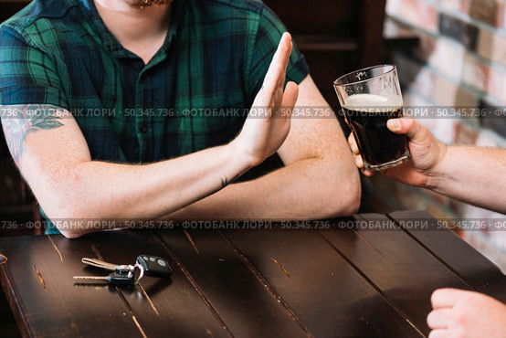 man refusing glass rum offered by his friend. Стоковое фото, агентство Ingram Publishing / Фотобанк Лори