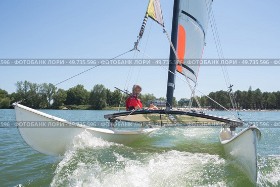 man sailing with sails out on a sunny day. Стоковое фото, агентство Ingram Publishing / Фотобанк Лори