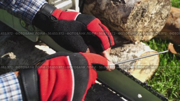 Man sharpening chainsaw chain before work. Стоковое видео, видеограф Igor Skripachev / Фотобанк Лори