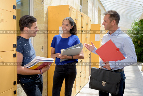 man showing young couple the locker room. Стоковое фото, агентство Ingram Publishing / Фотобанк Лори