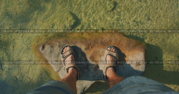Man standing on large rock under clear shallow water of Cetina river in Croatia. Стоковое видео, видеограф Igor Tichonow / Фотобанк Лори