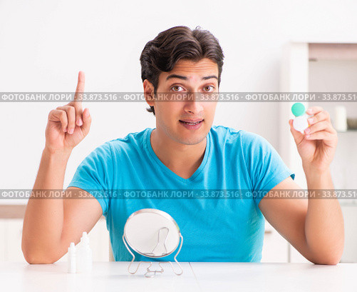 Man trying contact lenses at home. Стоковое фото, фотограф Elnur / Фотобанк Лори