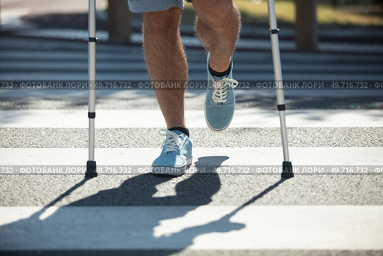 man trying to walk on street with the help crutches. Стоковое фото, агентство Ingram Publishing / Фотобанк Лори