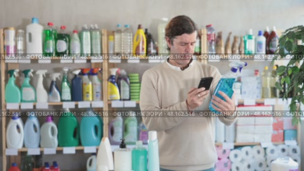 Man uses barcode to get information about glass cleaner spray in mobile application. Стоковое видео, видеограф Яков Филимонов / Фотобанк Лори