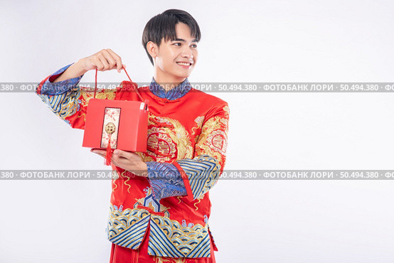 Man wear Cheongsam ready to give red bag to sister for surprising in traditional day. Стоковое фото, агентство Ingram Publishing / Фотобанк Лори