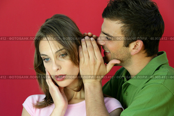 Man whispering a secret to a young woman. Стоковое фото, агентство Ingram Publishing / Фотобанк Лори