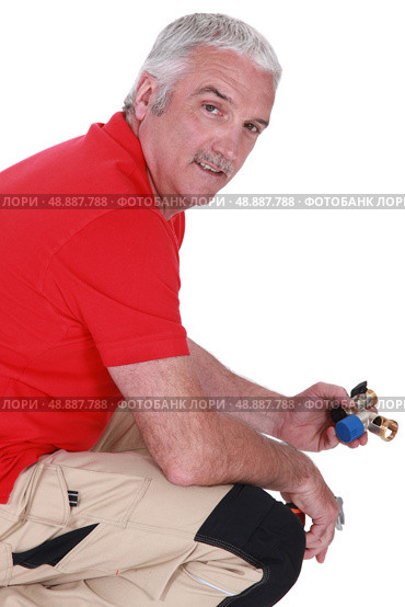 Man with a piece of plumbing. Стоковое фото, агентство Ingram Publishing / Фотобанк Лори