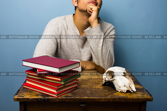 Man with books and animal skull. Стоковое фото, агентство Ingram Publishing / Фотобанк Лори