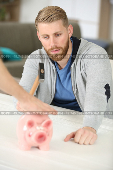 man with hammer poised over piggybank. Стоковое фото, агентство Ingram Publishing / Фотобанк Лори