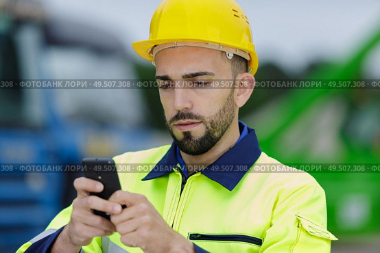 man with hard helmet talking on the phone. Стоковое фото, агентство Ingram Publishing / Фотобанк Лори