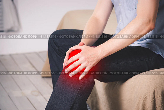 Man with pain in knee suffering at home. Стоковое фото, фотограф Станислав Тарко / Фотобанк Лори