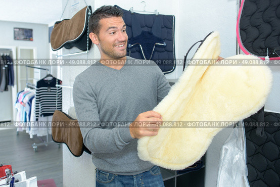 Man with surprised expression holding horse blanket. Стоковое фото, агентство Ingram Publishing / Фотобанк Лори