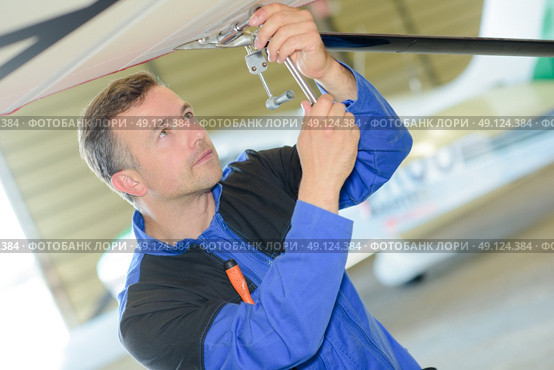 Man working on the underside of an aircraft. Стоковое фото, агентство Ingram Publishing / Фотобанк Лори