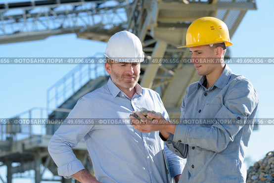 manager and worker with safety helmet outside a factory. Стоковое фото, агентство Ingram Publishing / Фотобанк Лори