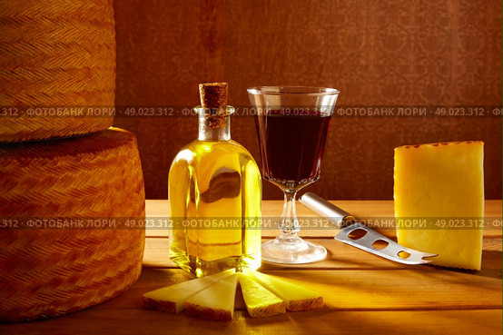 Manchego cheese from Spain with olive oil and red wine on wood. Стоковое фото, агентство Ingram Publishing / Фотобанк Лори