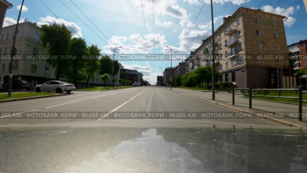 Машина поворачивает на перекрестке на проспект Ленина в центре города Петрозаводска. Солнечный летний день, вид от первого лица с капота машины (2023 год). Редакционное видео, видеограф Sergei Gorin / Фотобанк Лори