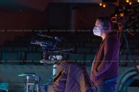 masked cameraman is filming a television show in the studio. TV. Стоковое фото, агентство Ingram Publishing / Фотобанк Лори