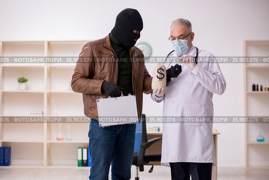 Masked man burglar bribing old doctor for getting vaccine. Стоковое фото, фотограф Elnur / Фотобанк Лори