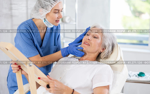 Mature patient with mirror, doctor with gloves. Стоковое фото, фотограф Яков Филимонов / Фотобанк Лори