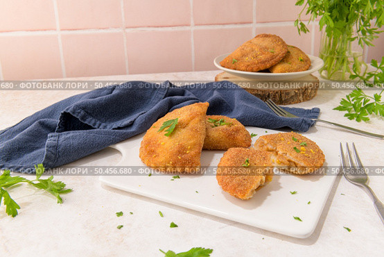 Meat patties and parsley leaves on white ceramic dishes in a kitchen counter top. Стоковое фото, агентство Ingram Publishing / Фотобанк Лори