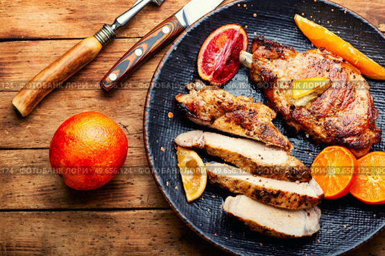 Meat steak cooked in oranges. Cutting in slices flank steak. Meat in citrus on old wooden table. Meat steak fried with citrus fruits. Стоковое фото, агентство Ingram Publishing / Фотобанк Лори
