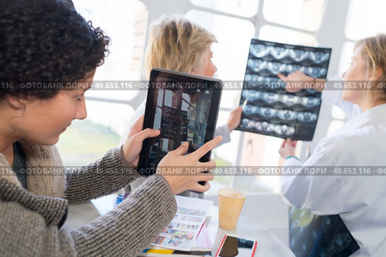 medical staff looking at xrays and tablet screen. Стоковое фото, агентство Ingram Publishing / Фотобанк Лори