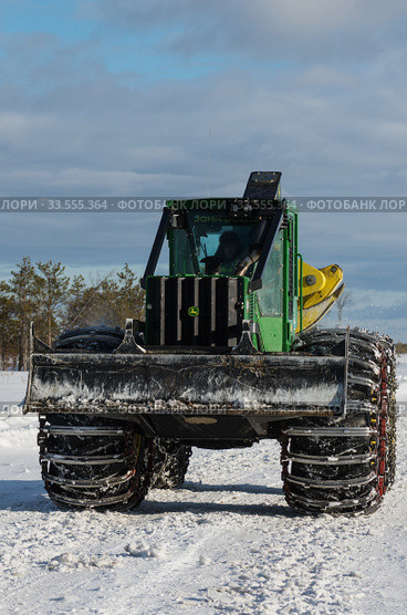 Механизированная рубка леса. Трелевочный трактор John Deere 748H едет по дороге. Mechanized felling clearing. John Deere 748H skidder rides on the road. Стоковое фото, фотограф Евгений Романов / Фотобанк Лори
