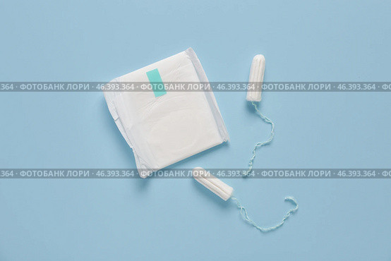 Menstrual pad and tampons on blue background. Стоковое фото, фотограф Pixel_shot / Фотобанк Лори