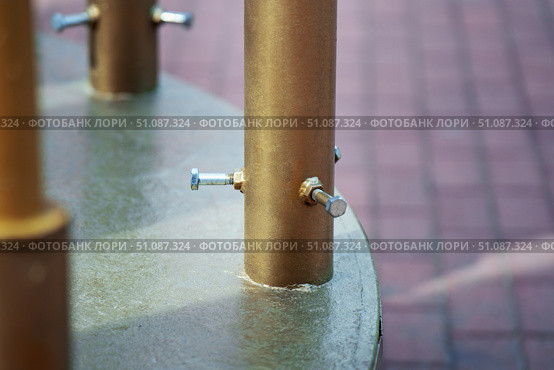 Metal pipe with three bolts securing a smaller diameter pipe inside, showcasing industrial fastening and mechanical construction. Стоковое фото, фотограф Татьяна Степанищева / Фотобанк Лори