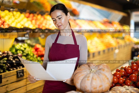 Middle-aged female seller restocking with paper in grocery market. Стоковое фото, фотограф Яков Филимонов / Фотобанк Лори