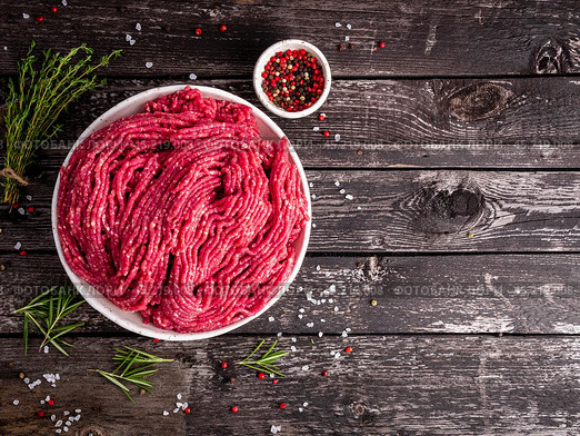 Mince beef, ground meat with ingredients for cooking on dark blue. Стоковое фото, фотограф Natalia Gdovskaia / Фотобанк Лори
