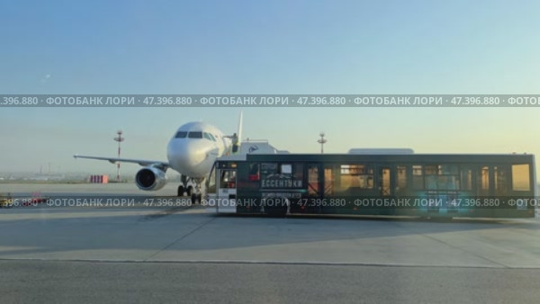 Mineralnye Vody, Russia - 09.03.2024: Bus waits for people descending airplane stairs to transfer to airport. Shuttle service provides a convenient transit for arriving and departing passengers. Редакционное видео, видеограф Ирина Михайличенко / Фотобанк Лори