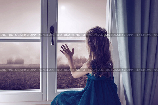 Miserable child looking through window. Стоковое фото, агентство Ingram Publishing / Фотобанк Лори