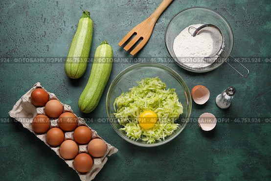 Миски с тертыми цуккини, мукой и яйцами для приготовления оладий на зеленом фоне. Стоковое фото, фотограф Pixel_shot / Фотобанк Лори