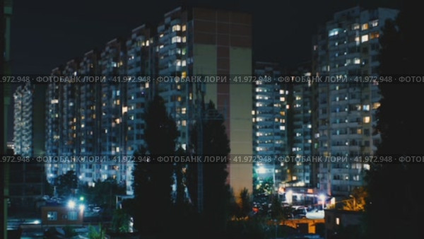 Многоэтажные жилые дома ночью. Отблески света в окнах. По улицам ездят автомобили. Таймлапс ночной жизни города (2021 год). Стоковое видео, видеограф Воловодов Владимир / Фотобанк Лори