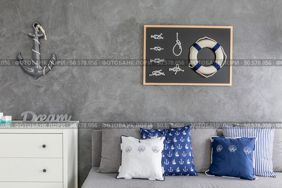 Modern flat with nautical decorations, sofa with pattern pillows and white commode. Стоковое фото, агентство Ingram Publishing / Фотобанк Лори