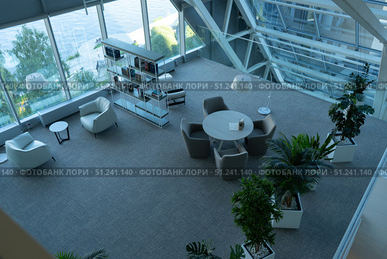 Modern Indoor Space Featuring Contemporary Furniture, Lush Plants, and Large Windows, Creating an Inviting and Open Atmosphere for Relaxation and Collaboration. Стоковое фото, фотограф Владимир Федоров / Фотобанк Лори